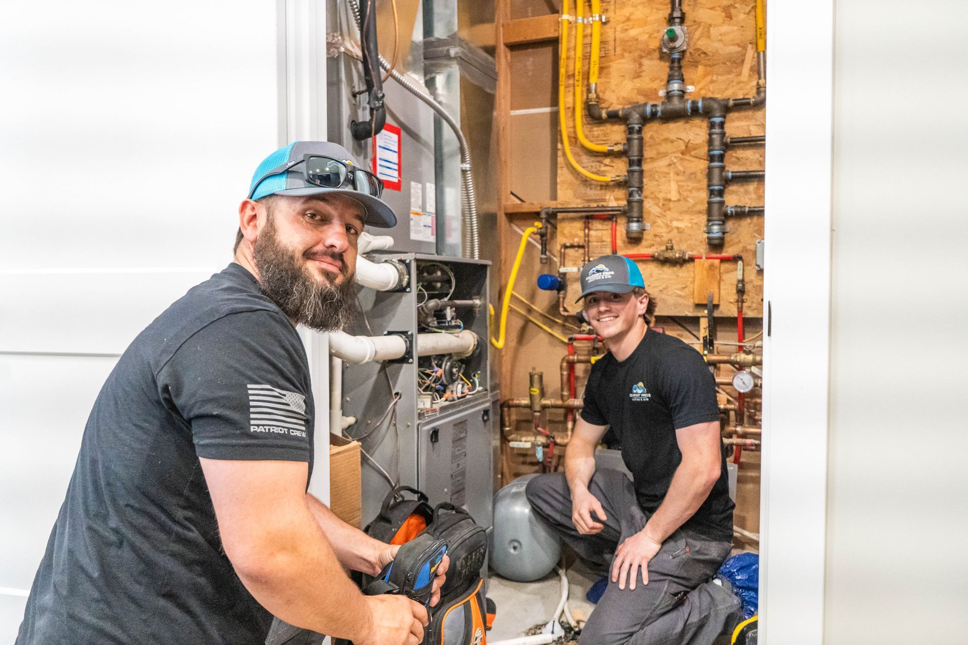 A furnace is sitting in a basement covered in insulation.