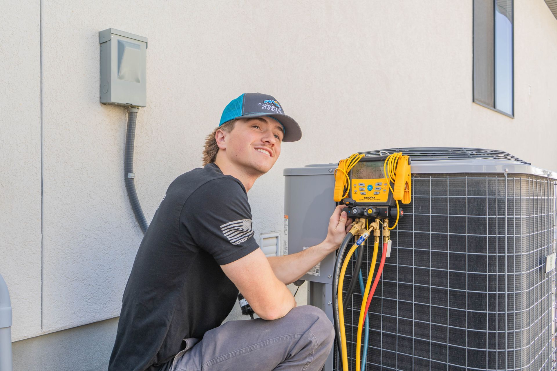 A plumber is standing in front of a water heater holding a wrench.