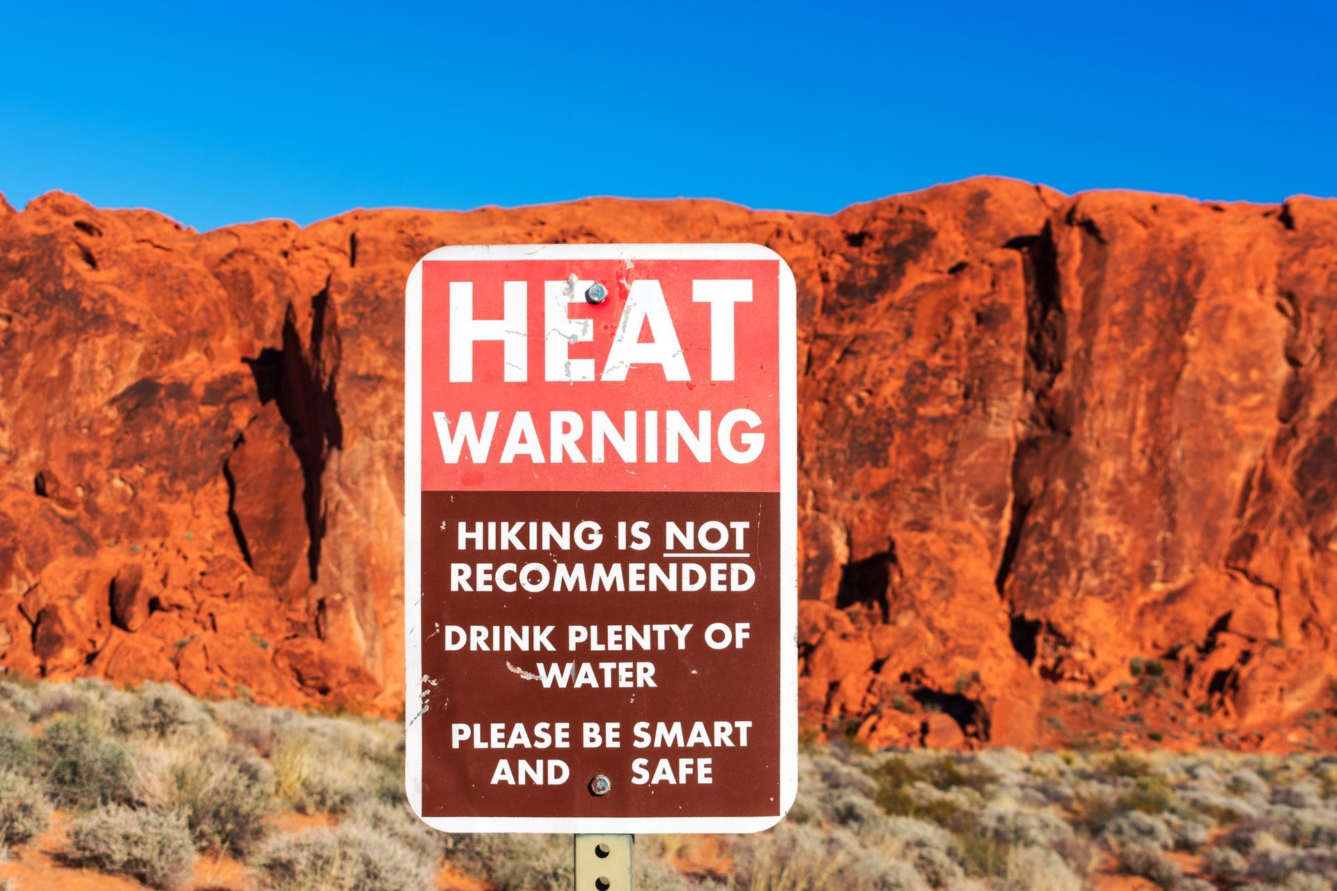 Extreme Heat warning sign informs tourists of the dangers of heat exhaustion from hiking in desert.