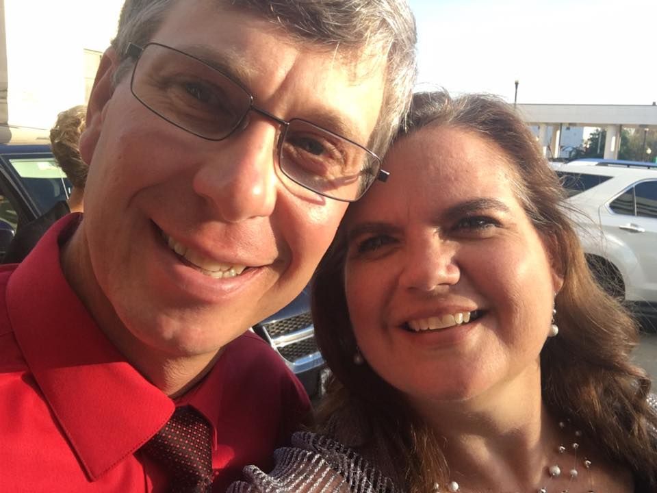 A man and a woman are posing for a picture and smiling