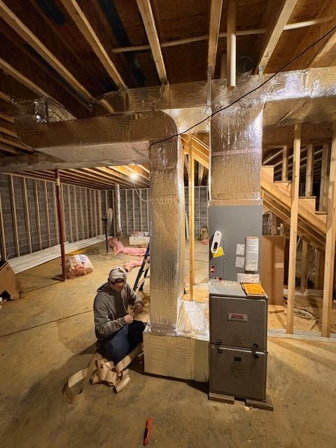 An aerial view of a large brick house surrounded by trees and grass.