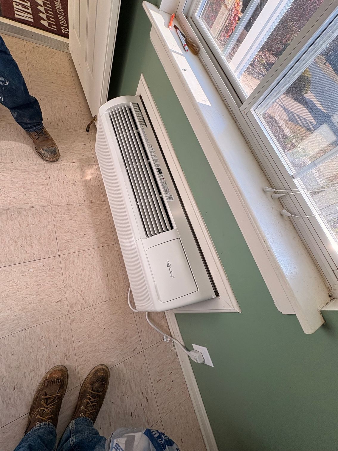 A large house with a blue roof is sitting on top of a lush green lawn.