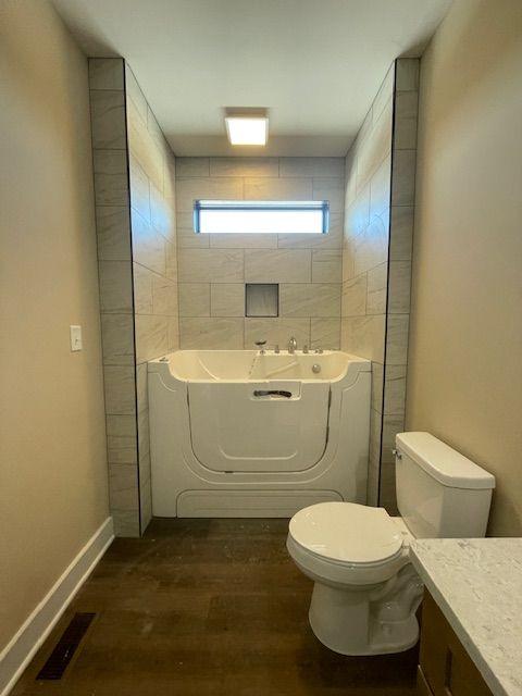 An aerial view of a large brick house surrounded by trees and grass.