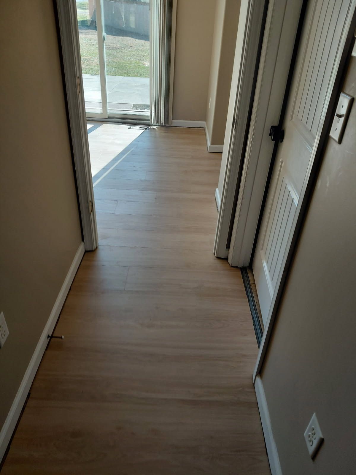 A large house with a blue roof is sitting on top of a lush green lawn.