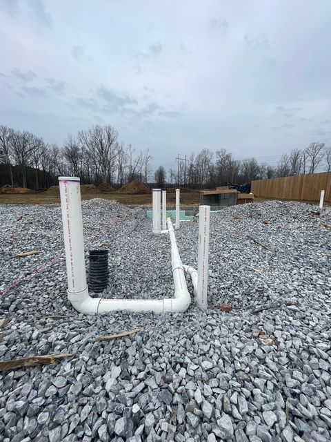 A large house with a blue roof is sitting on top of a lush green lawn.