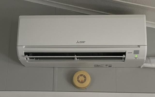 A large house with a blue roof is sitting on top of a lush green lawn.