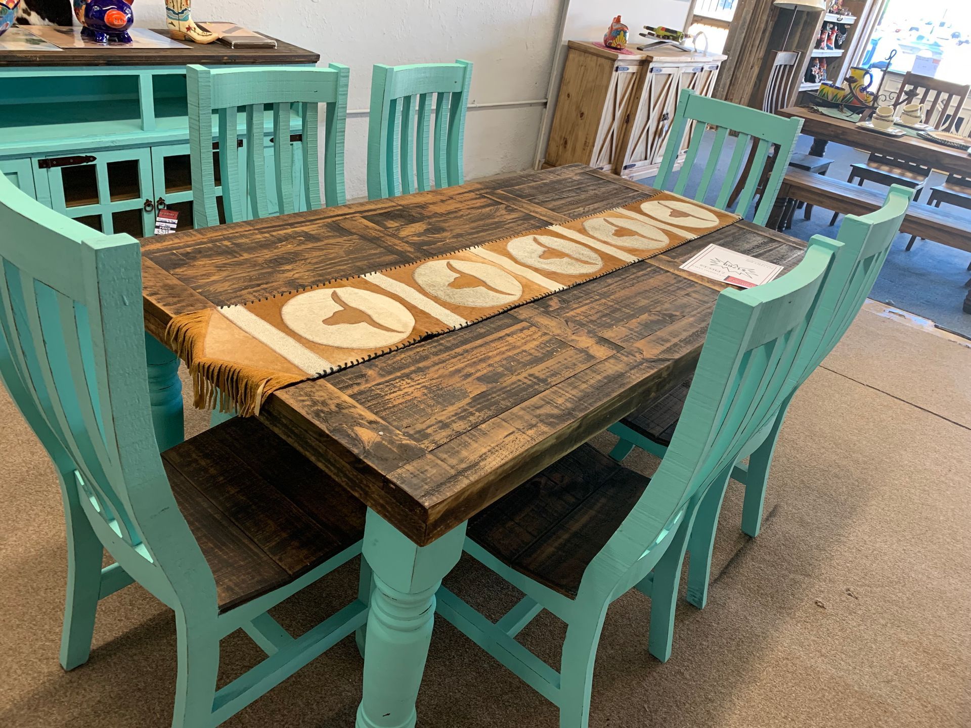 Rustic turquoise and brown dining table with bench and chairs.