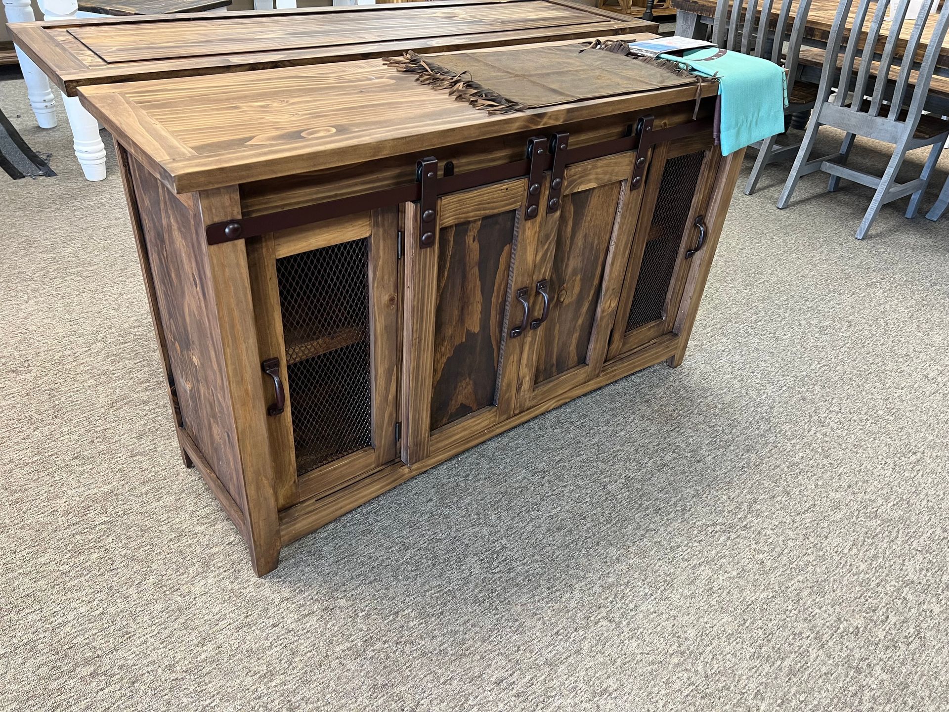 Wooden cabinet with mesh doors and a dark wood top.