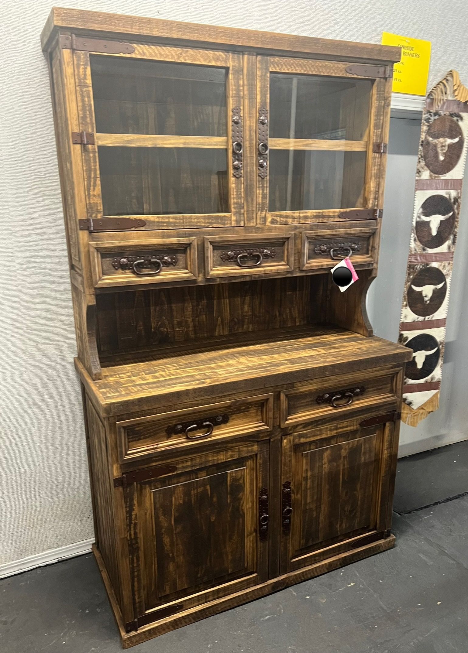 Wooden hutch with glass-door upper section, drawers, and cabinet doors; stained dark brown.
