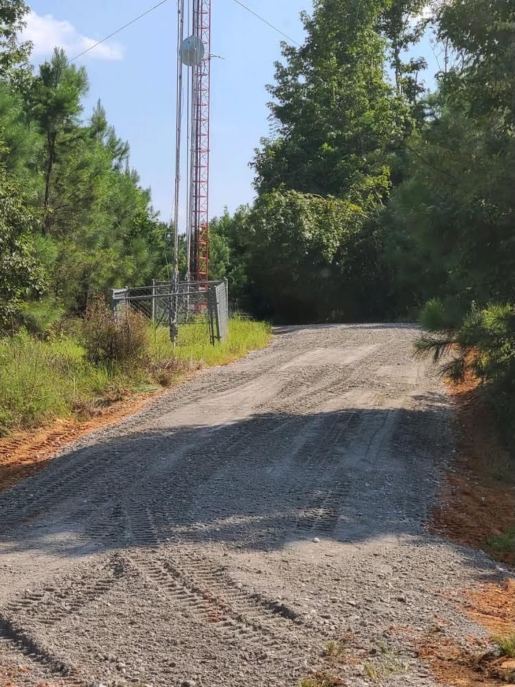 A dirt road with a water tower in the background