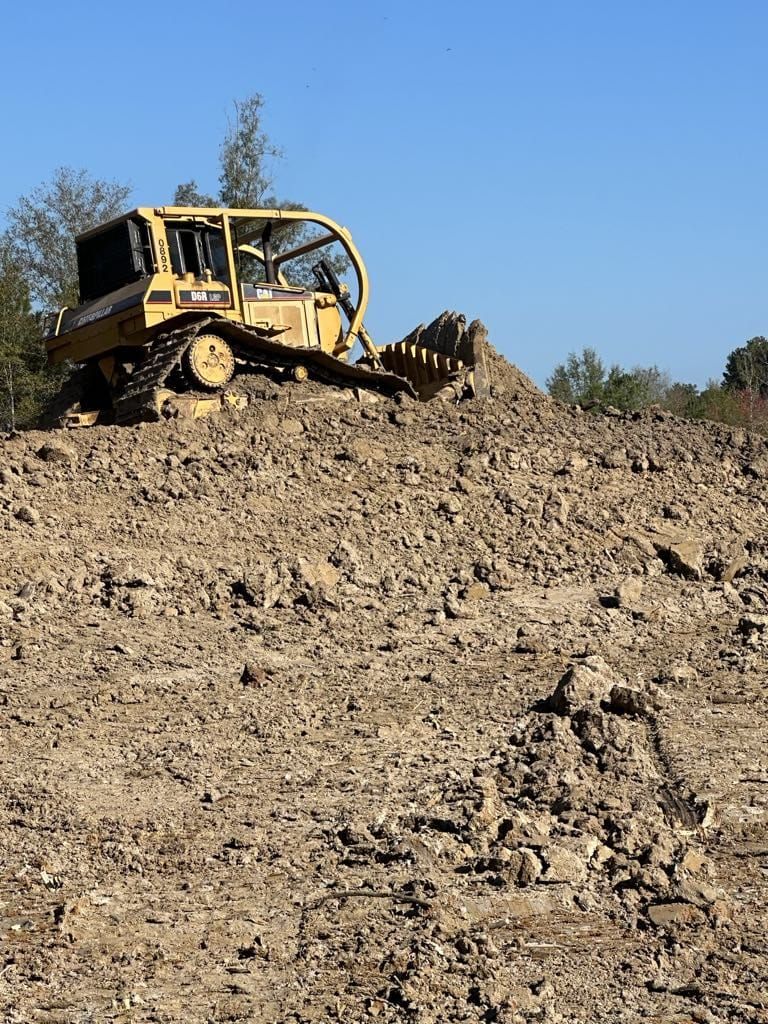 A bulldozer is sitting on top of a dirt hill.
