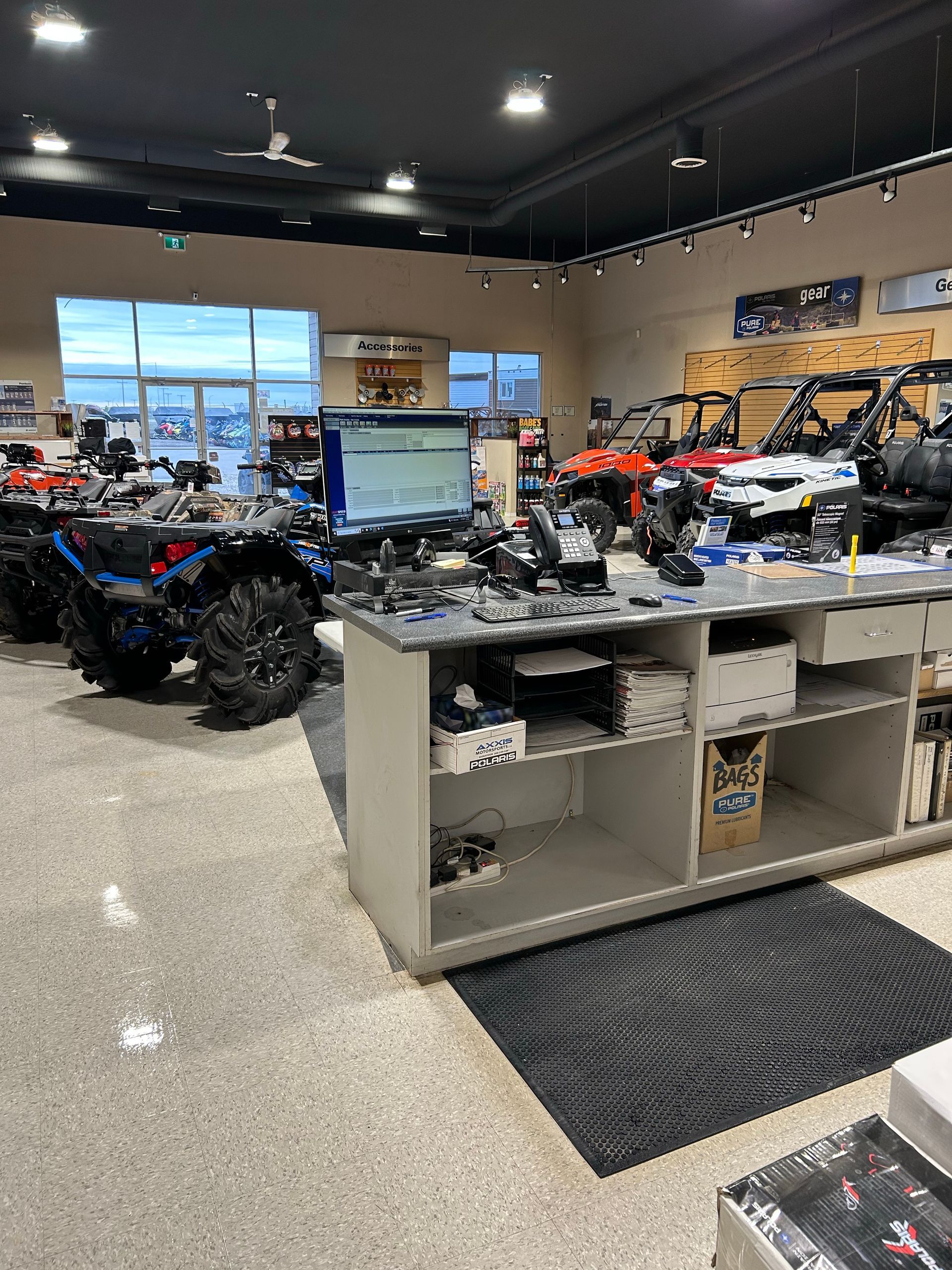 A row of atvs are lined up in a showroom.