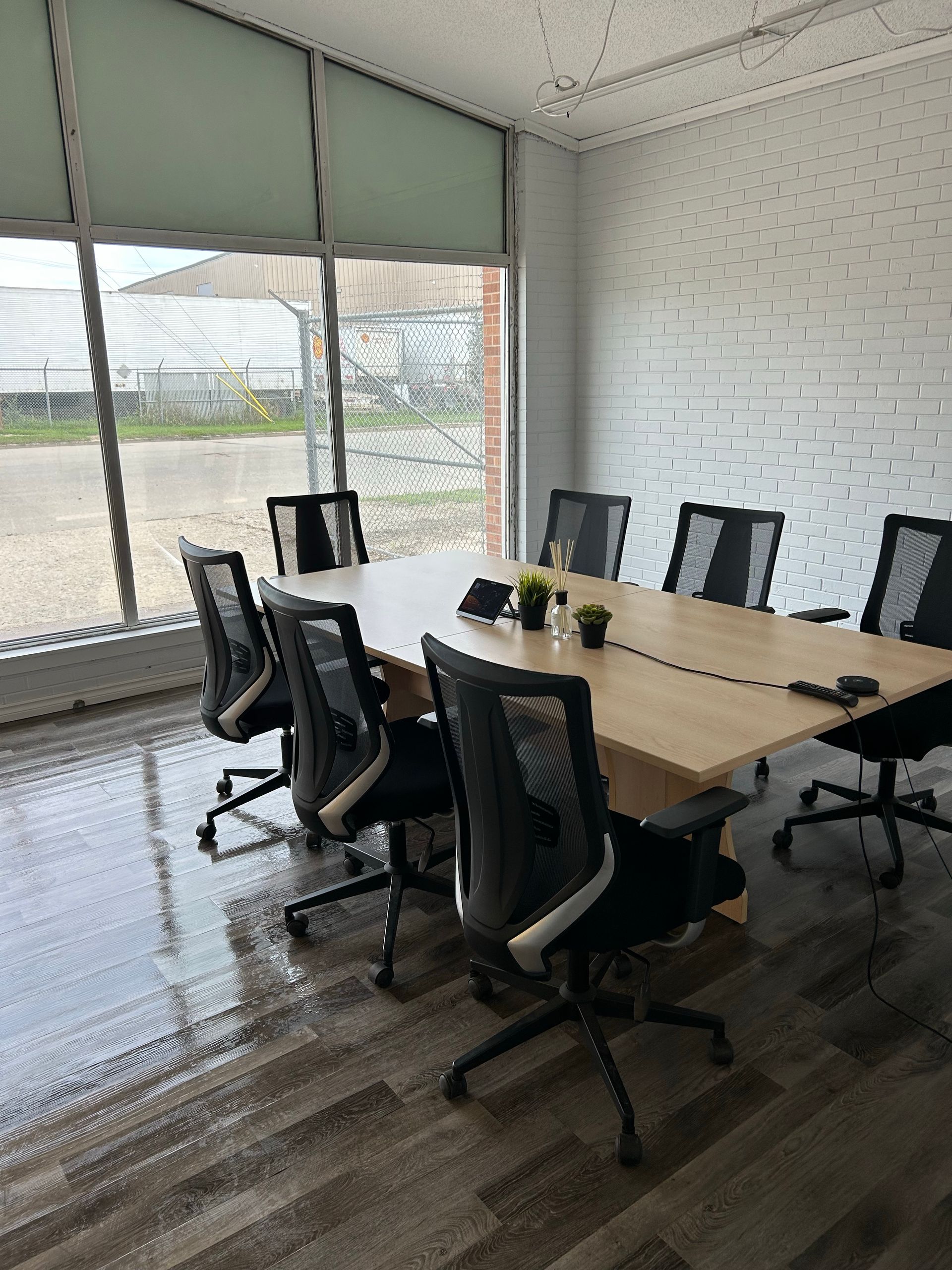 A conference room with a long table and chairs.