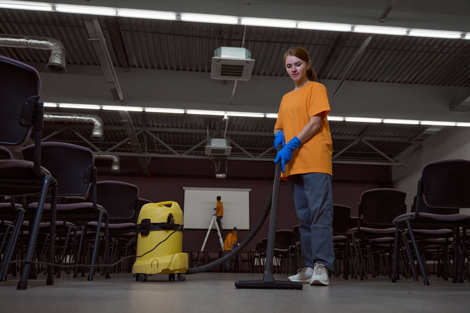 A woman is cleaning a room with a vacuum cleaner.