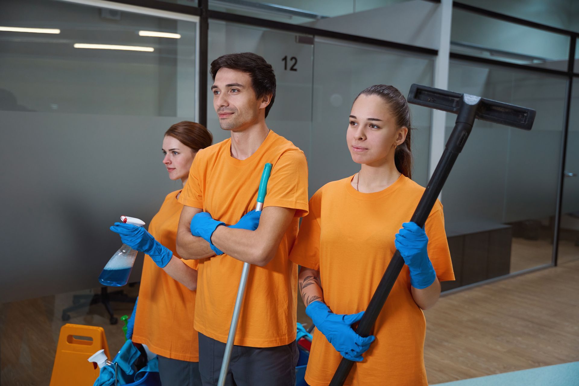 A group of people are cleaning an office with a vacuum cleaner.