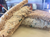 Close-up of a sliced sandwich with breaded filling on a plate
