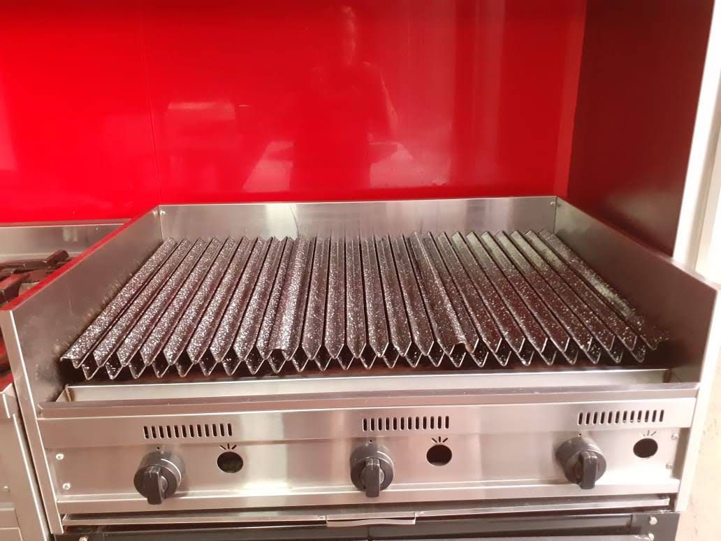 Parrilla comercial de acero inoxidable con tres quemadores y fondo rojo.