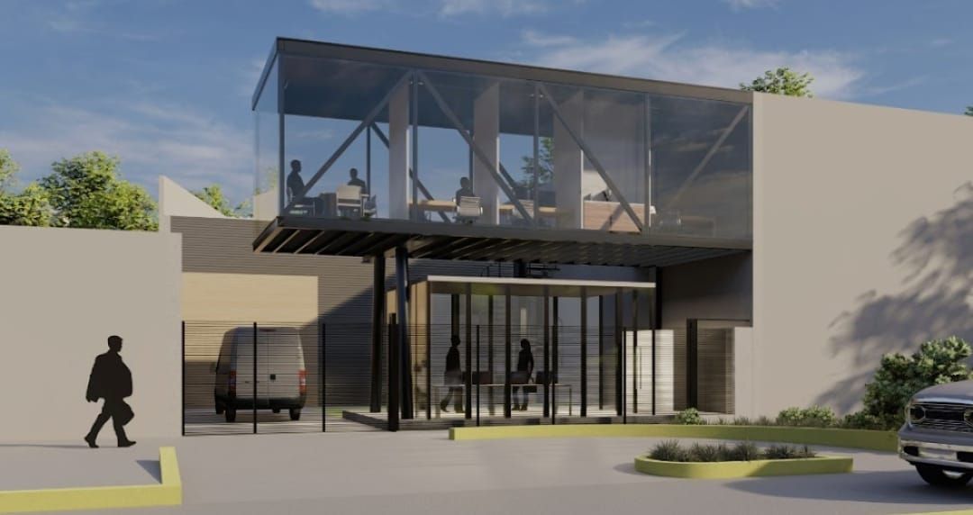 Edificio moderno con segundo piso de cristal, con gente en el interior y entrada inferior.