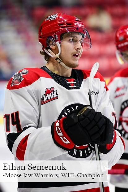 Ethan Semeniuk of the WHL champion Moose Jaw Warriors wearing a red helmet and white and black team jersey on the ice.
