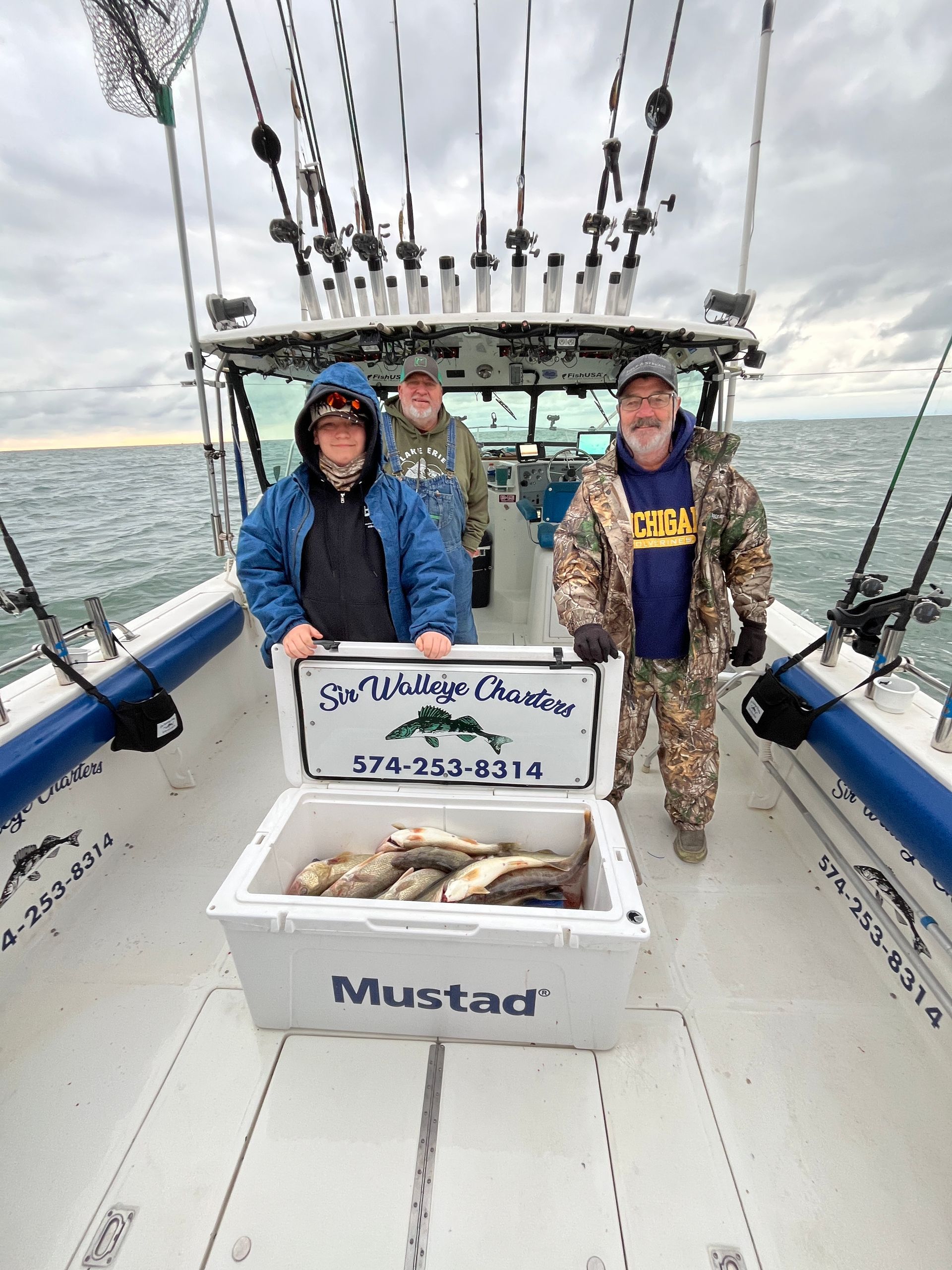 Group of clients gathered around the cooler full of Lake Erie walleyes on the Sir Walleye boat!