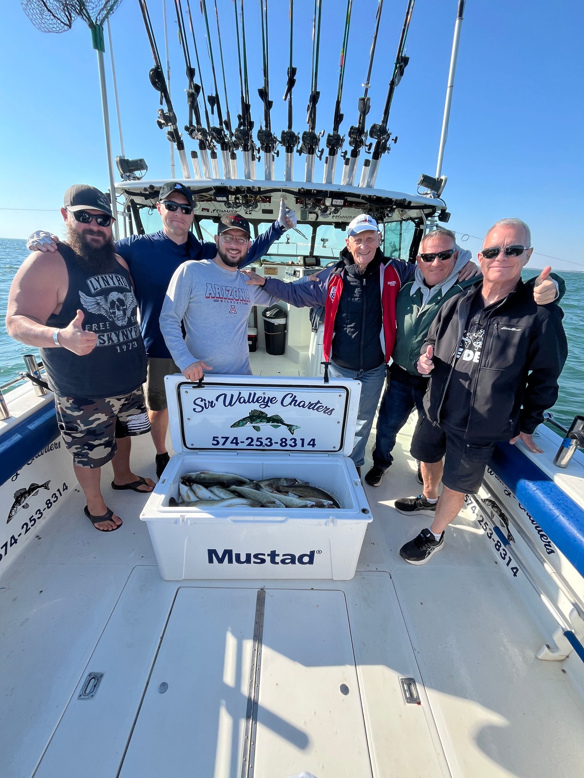 Group of Lake Erie Anglers gathered around their limit catch in the cooler on Sir Walleye 