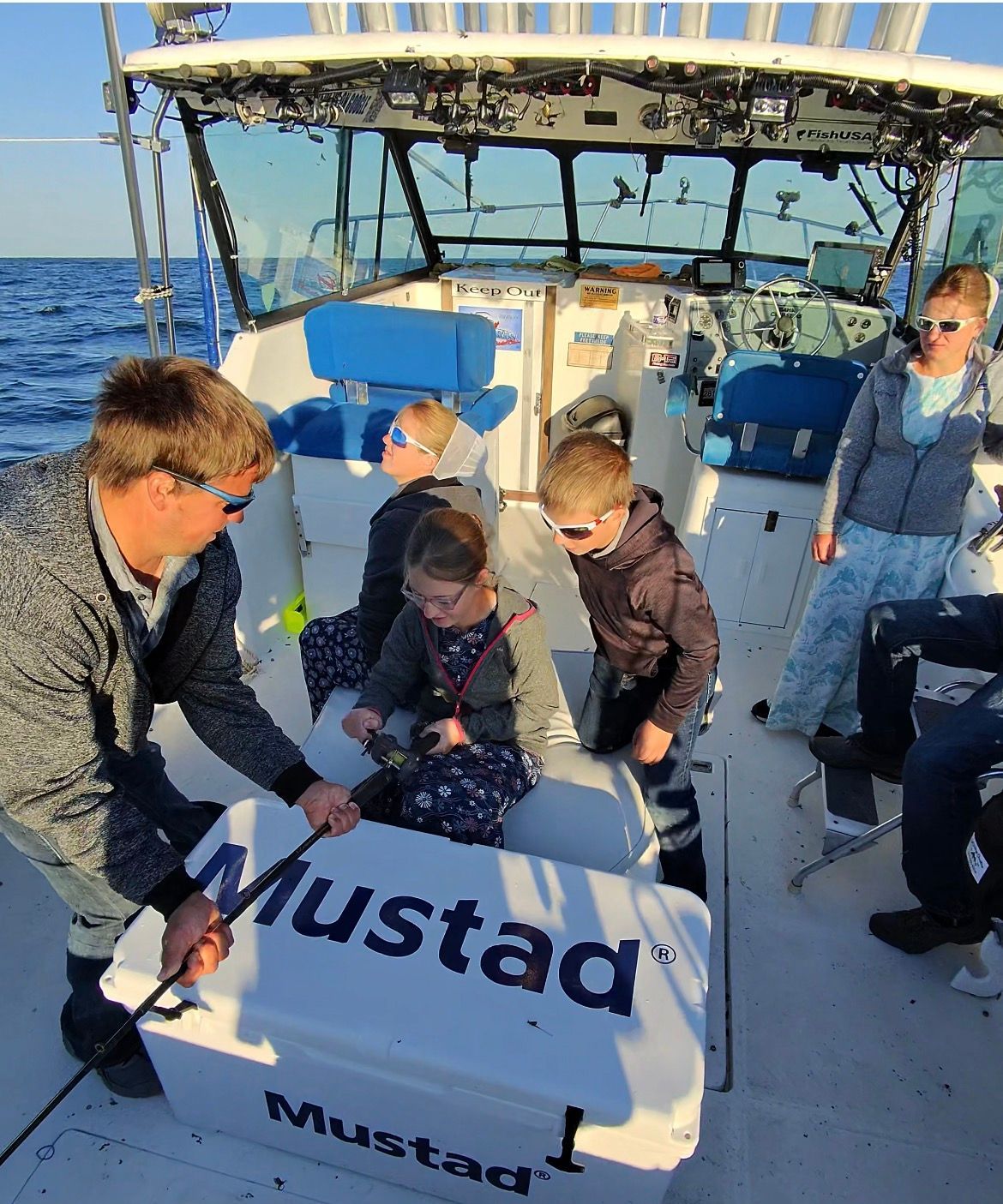 Group of kids reeling in Lake Erie Walleyes.