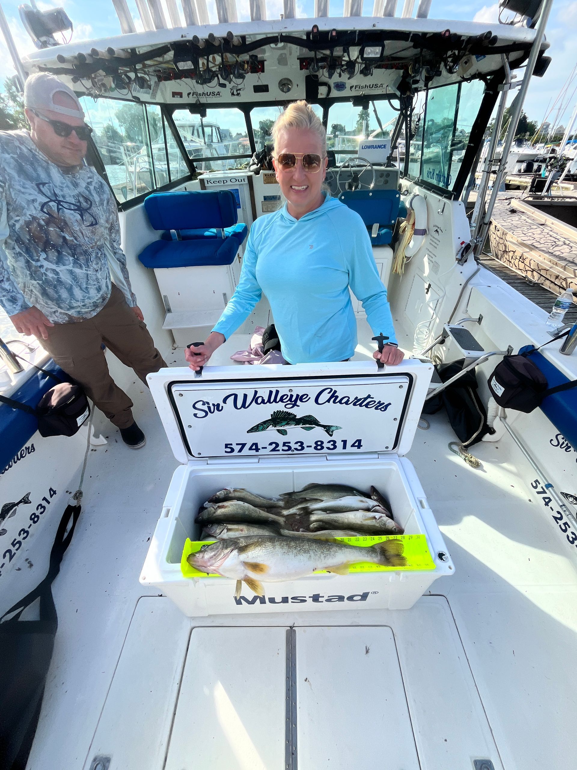 A women with a Fish Ohio and a cooler full of Lake Erie Walleye's.
