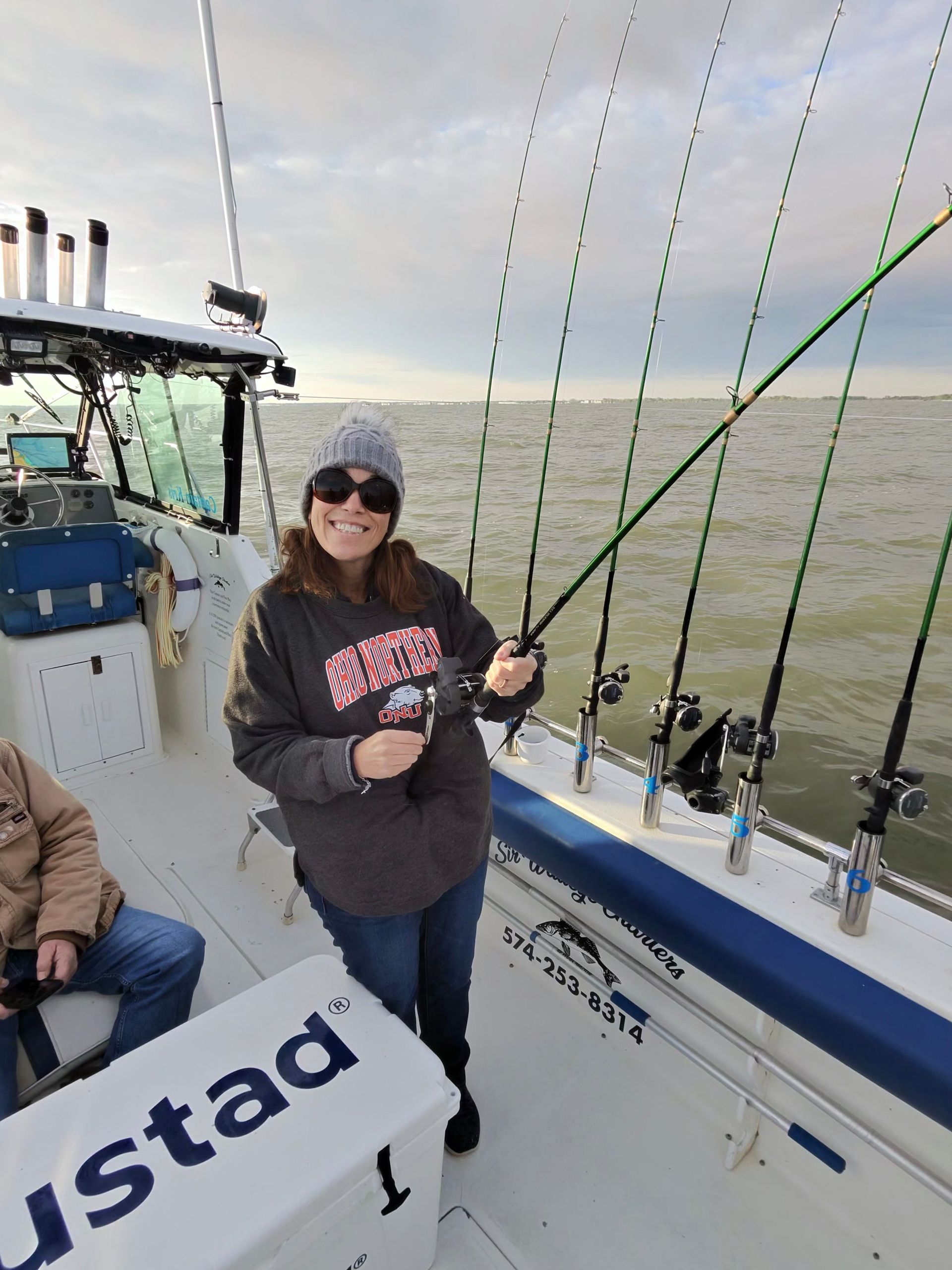 A Women reeling in a Lake Erie Walleye on the Sir Walleye Charters boat