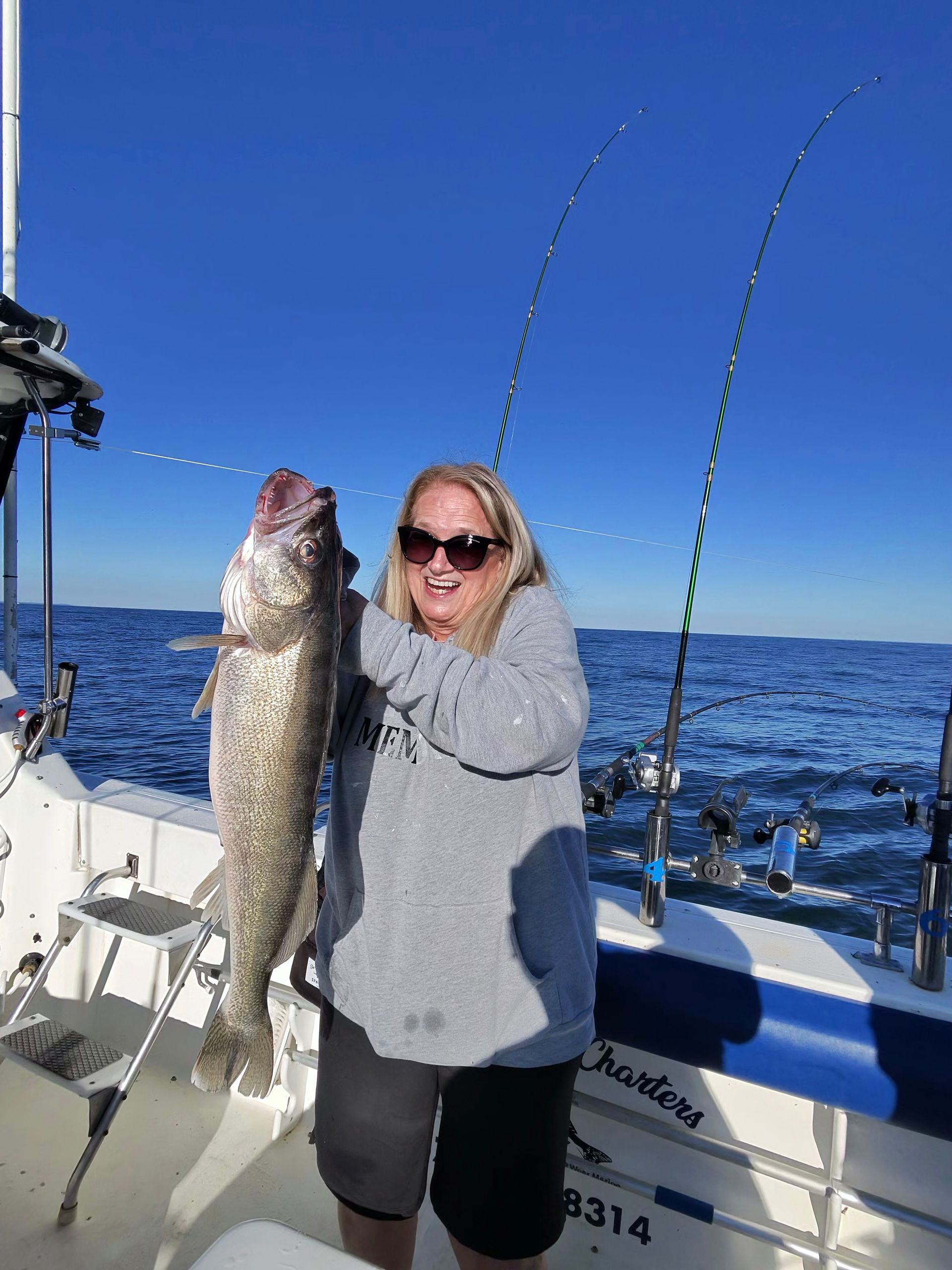 Women holding by the gills a 28 inch Lake Erie Walleye.