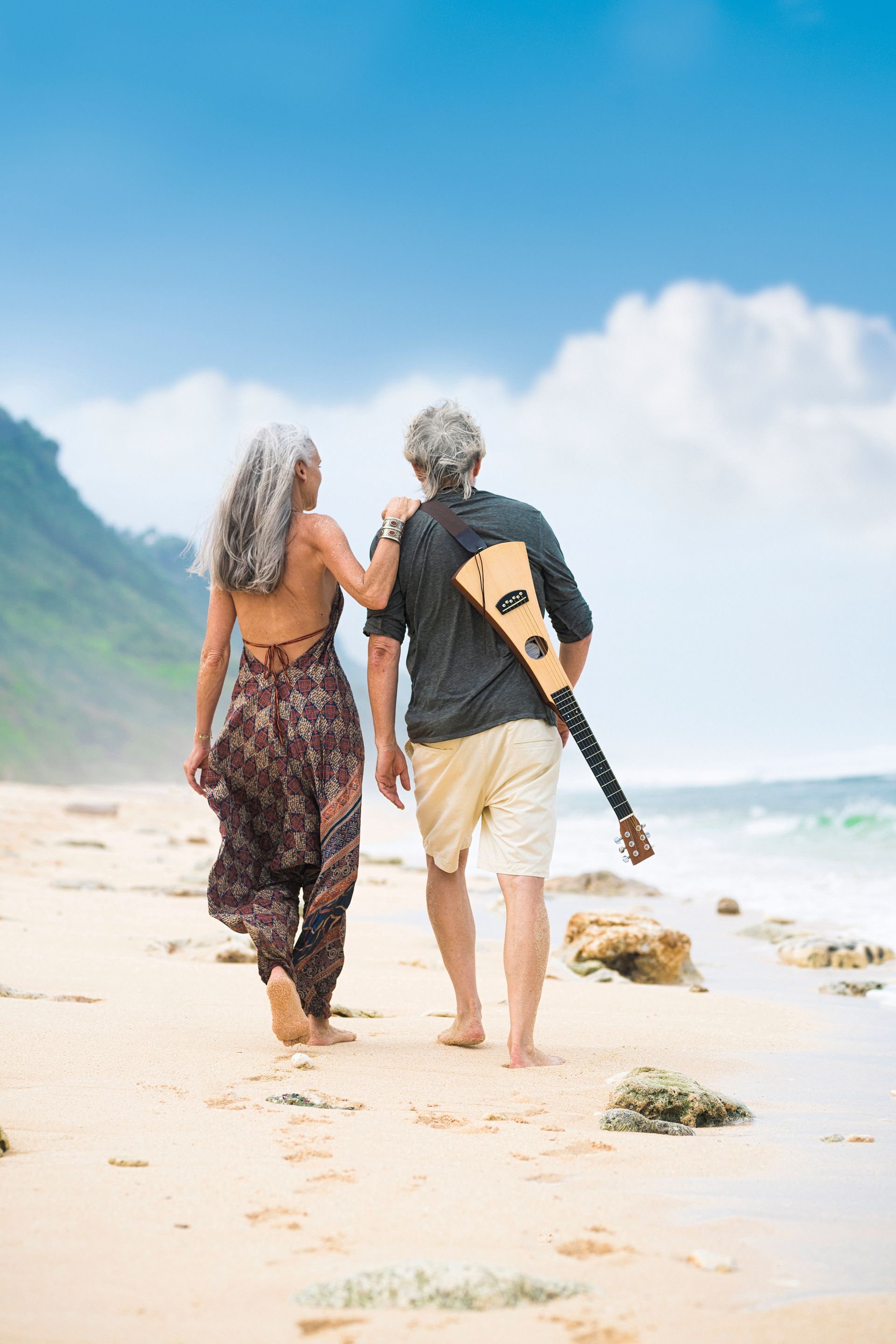 Couple dancing outdoors in a garden; man wearing blue shirt, woman cream top; green foliage, house in the background.