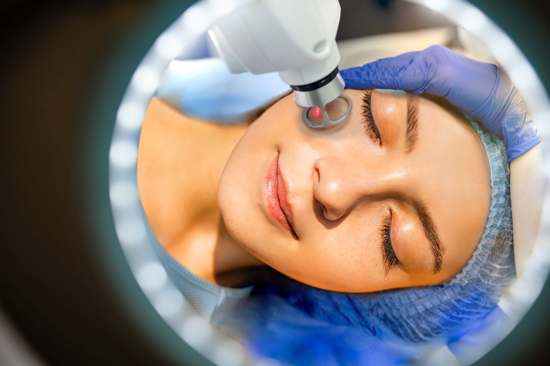 A woman is getting a laser treatment on her face.