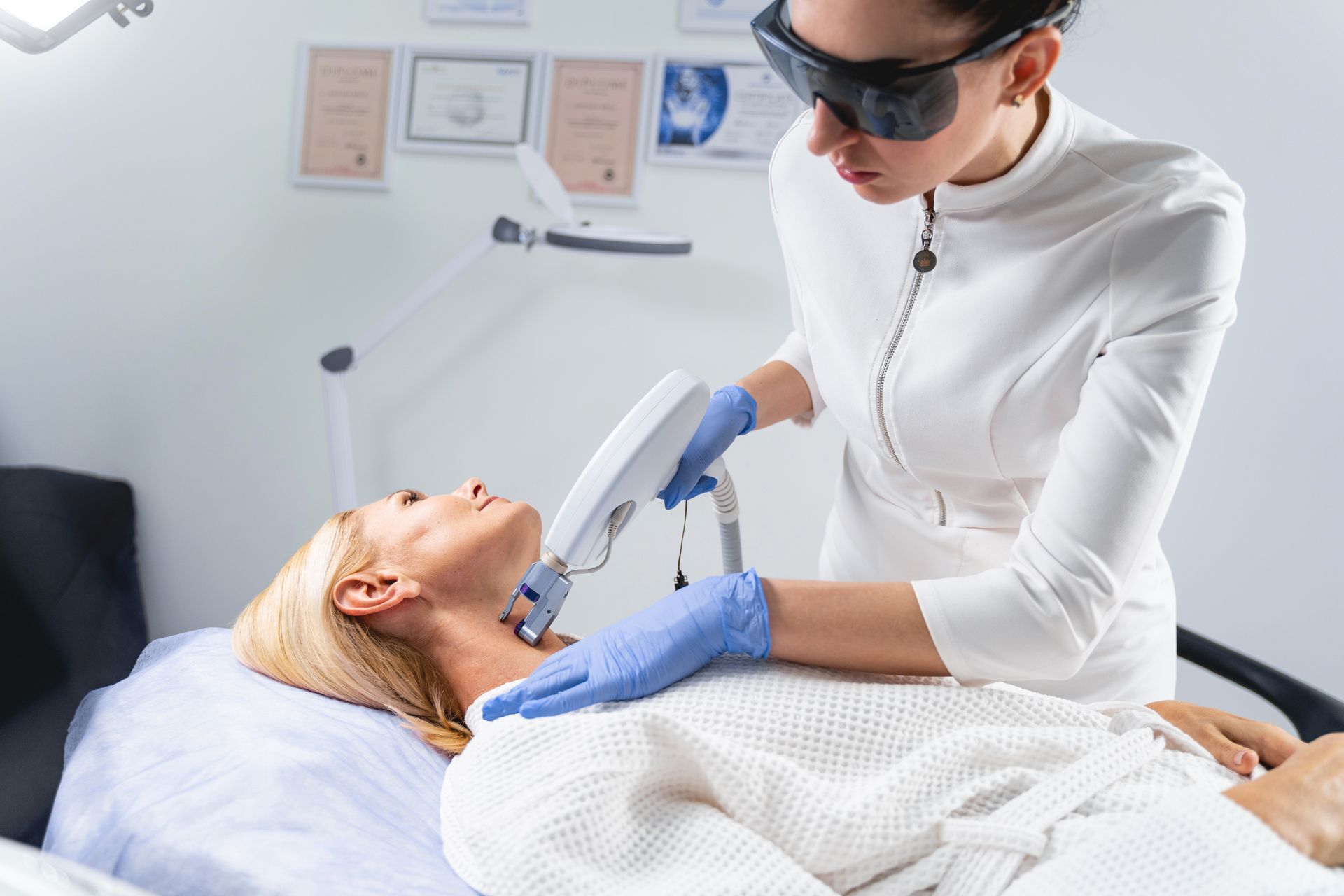 A woman is getting a laser hair removal treatment on her neck.