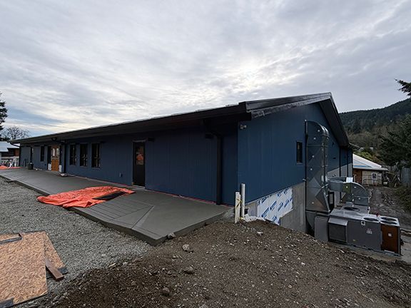 Concrete steps and platform being added to the front of Windsor Plywood Ganges' location.