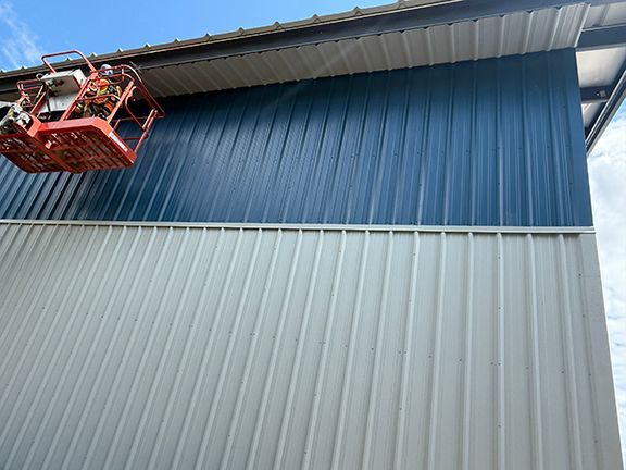 Teams adds final touches to metal building wall and roof systems.