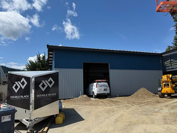 Double Black Construction trailer in front of metal building project in Salt Spring Island.