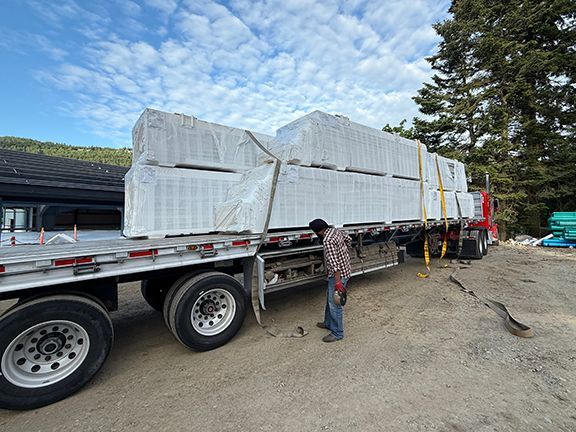 Truck and trailer delivers insulated metal panels to construction site in BC.