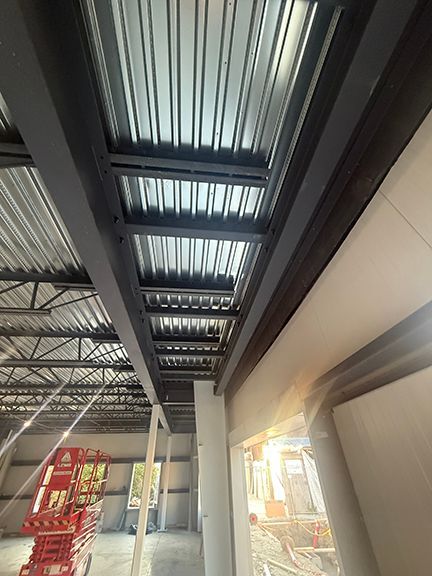View of steel i-beams that support metal flooring panels at PEMB project.