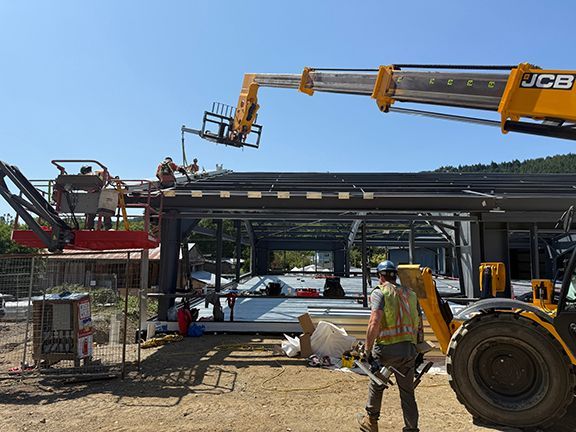 Trades team works on adding metal structural beams to building project.