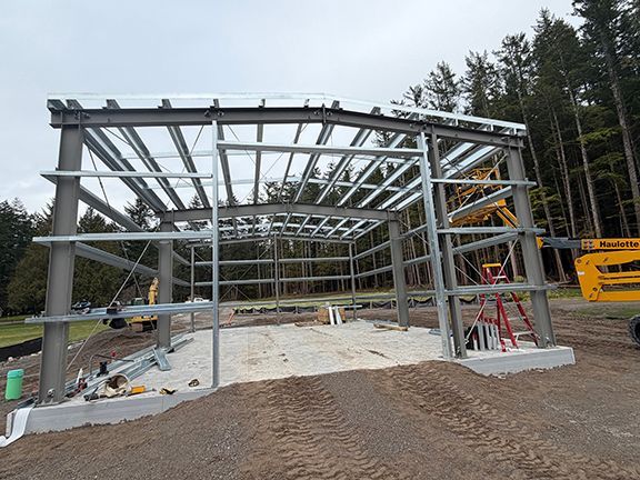 A metal building frame under construction in Squamish by Double Black Construction.