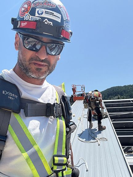 John Lohan directs Double Black Construction team on metal roof in BC.