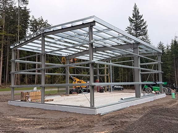 Nice view of a nearly complete metal building framing atop a concrete foundation.