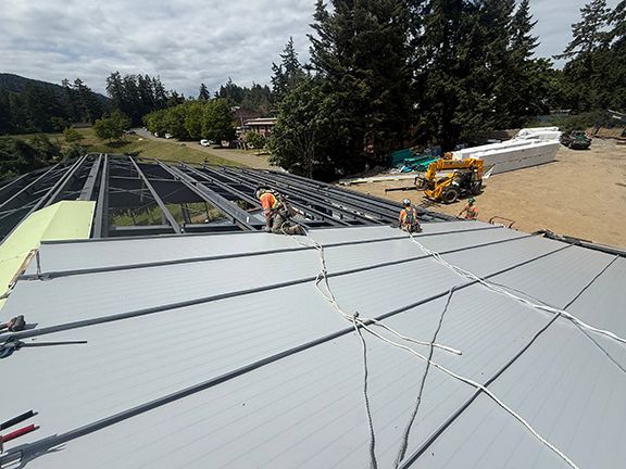 Metal roofing panels being added to structure in BC.