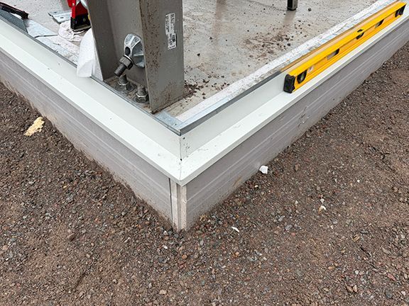 Closeup of the concrete foundation and imbedded steel I-beam frame.