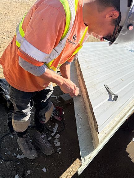 Insulated metal panel being cut to size by skilled tradesperson.