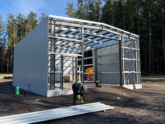 Metal wall panels being cut to fit by skilled tradesperson.