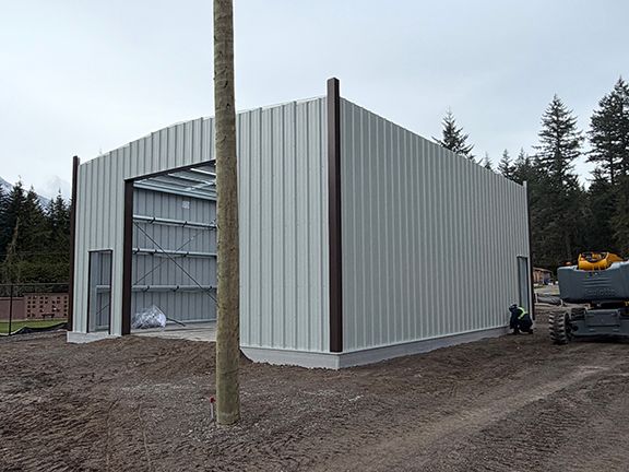 A large, light-colored metal storage building under construction just before roofing gets added.