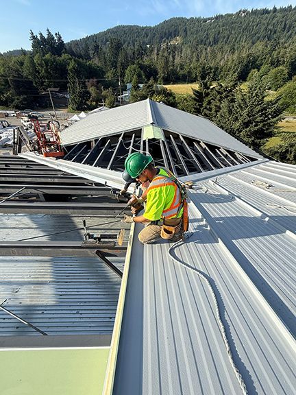 Skilled tradesman installs IMP on metal building roof.