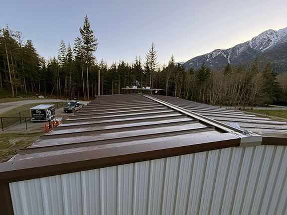 A view from the roof of a metal building with brown metal panels in Squamish, British Columbia.