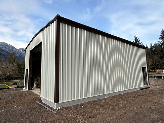 Side view of the metal building project with completed wall and roof panels.
