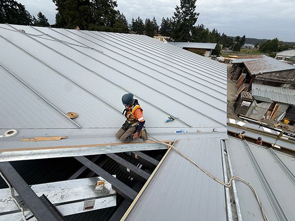 Pre-engineered steel roofing system being installed on Salt Spring Island project.